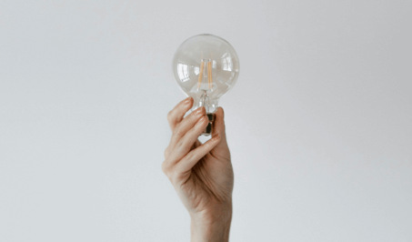 A hand holding a lightbulb