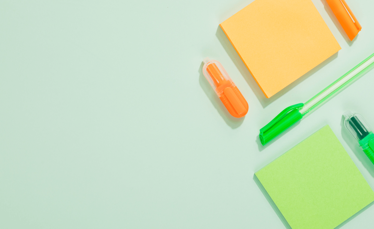 Blank sticky notes next to pens on a table