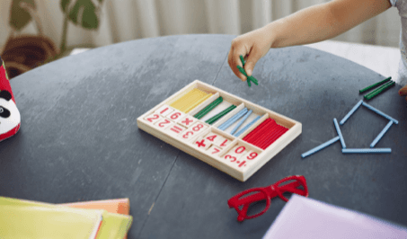 A child plays with a wooden math toy
